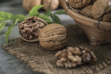 Walnuts in wooden bowl. Whole walnut on table