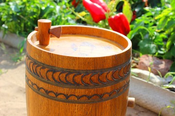 Wooden beer barrel and a field of red pepper.