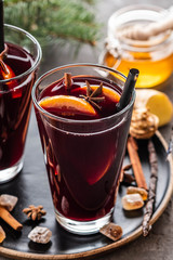 Hot mulled wine with spices, apple and orange on chrictmas background. Copy space.