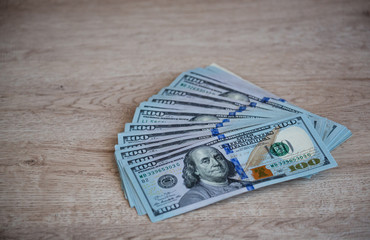 One hundred Dollars Money on a Wooden Background..