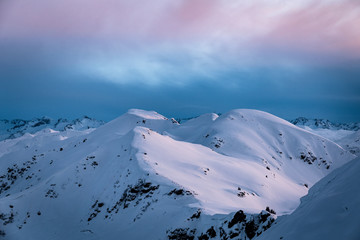 Stimmungsvolle Winterlandschaft mit Berge beim Sonnenuntergang