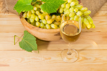 Glass of white wine against of fruit bowl with grape