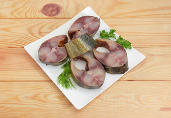 Smoked Atlantic horse mackerel slices with greens on square dish