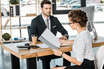 businessman and business partner with documents discussing work at workplace in office