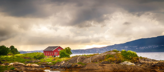 skandinavisches rotes Ferienhaus an einem Fjord, Norwegen