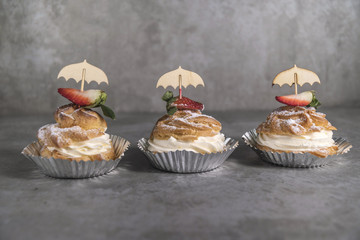 Homemade profiteroles with cream, strawberries and mint. Dessert for gourmets.