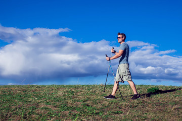 Nordic walking, exercise, adventure, hiking concept -man hiking in the nature