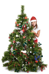 Beautiful smiling woman in Santa cap, behind the Christmas tree, isolated on white