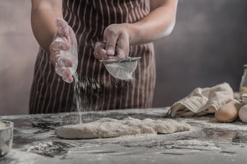 Man preparing buns at table in bakery