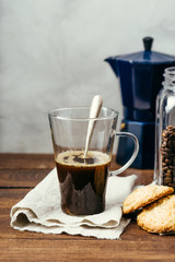 Black coffee and homemade cookies, on a wooden background, hot drink, transparent mug