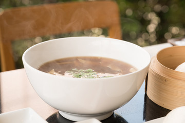 Hot soup and smoke in white bowl.