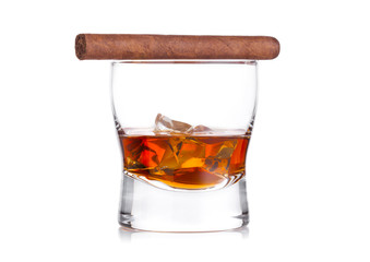 Glass of whiskey with ice cubes and cigar on white background. Cognac brandy drink