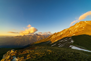 Obraz premium Dramatic sunset scene in high mountains. Clouds covering high peaks of Valais Alps (Pennine Alps), Switzerland in a evening light.