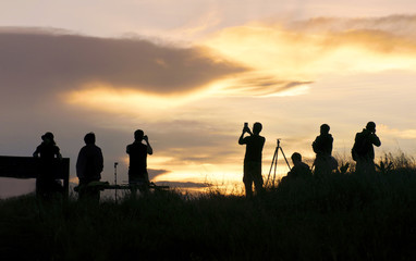 Fototapeta na wymiar silhouette of traveler taking picture of landscape during sunrise.
