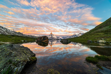 Morning shot of the golden Matterhorn (Monte Cervino, Mont Cervin) pyramid and blue Stellisee lake. Sunrise view of majestic mountain landscape.