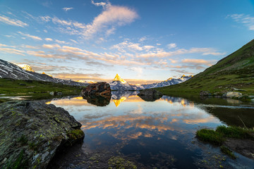 Obraz premium Morning shot of the golden Matterhorn (Monte Cervino, Mont Cervin) pyramid and blue Stellisee lake. Sunrise view of majestic mountain landscape. Valais Alps, Zermatt, Switzerland, Europe.