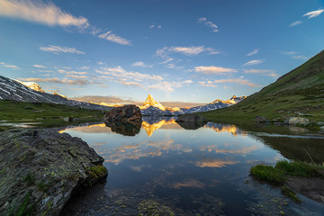 Obraz premium Morning shot of the golden Matterhorn (Monte Cervino, Mont Cervin) pyramid and blue Stellisee lake. Sunrise view of majestic mountain landscape. Valais Alps, Zermatt, Switzerland, Europe.