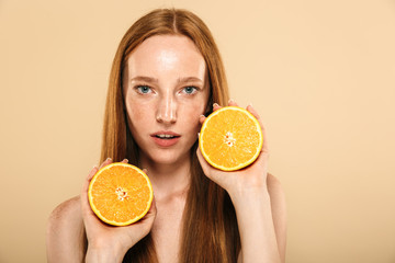 Redhead woman holding orange.