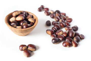 pile of chestnuts in a wooden bowl isolated
