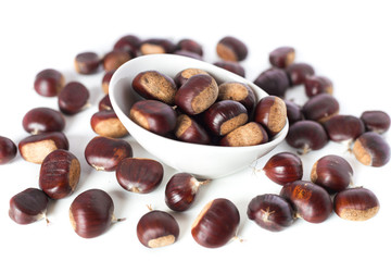 pile of chestnuts in a white bowl isolated
