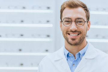 portrait of handsome professional optometrist in glasses in optica