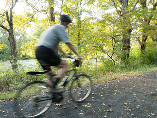 Motion Blur shot of a tall adult male riding a rails to trails bike on a path in Connecticut © kmlPhoto