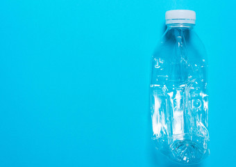 Transparent plastic bottle on a blue background..The concept of sorting polyethylene, household...