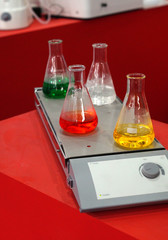 Closeup of Glass flasks with solutions shaker equipment