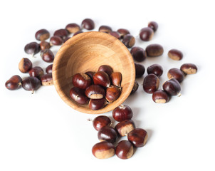 pile of chestnuts in a wooden bowl isolated
