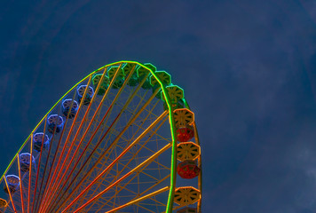 Colorful rainbow ferris wheel with evening sky background and copy space