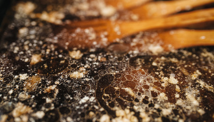 Wash dishes from fat. Fatty stains on a baking tray. Dishwasher concept.