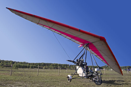 Motorized hang glider soaring in the blue sky