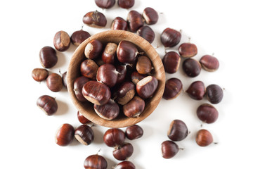 pile of chestnuts in a wooden bowl isolated
