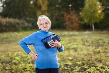 positive retired woman with a tape recorder in her hands