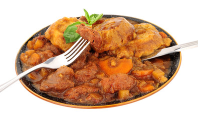Warming Winter beef and vegetable stew with dumplings isolated on a white background