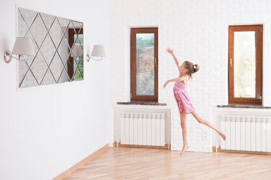 graceful little ballet dancer thin girl jumping in new bright room in house