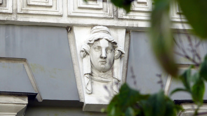 Decoration with sculptural mask on the wall of old building