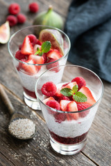 Chia pudding with strawberries in glass on wooden background, selective focus. Vegan meal, dieting, healthy eating concept