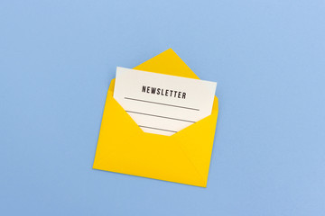 Minimalist composition of opened yellow envelope with blank paper newsletter e-mail on blue background