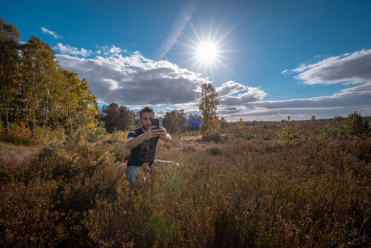 Mann fotografiert mit dem Smartphone