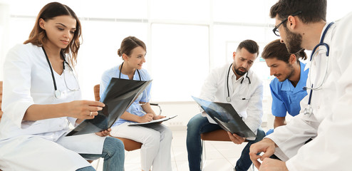 radiologists and a surgeon discussing a radiograph of a patient