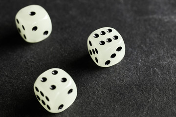 Close up picture of three fluorescent dice on a dark background, selective focus.