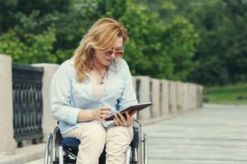 Woman in a wheelchair in the city park. The concept of an accessible environment for disabled...