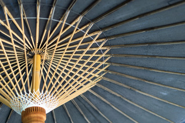 closeup handmade bamboo umbrella with soft-focus in the background and over light, lanna style, Thailand