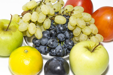 grapes on a plate, persimmon, plum apples and tangerine