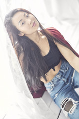 Naklejka premium A brunette female with long hair. Portrait of young beautiful makeup asian woman relax pink face. Smile happy asian beauty teenage girl on winter background banner.