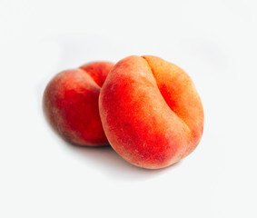 Saturn Peach isolated on white background. Flat peaches, two doughnut peaches in a pile.