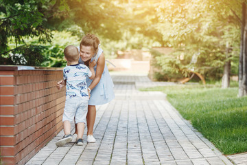 Young happy family: father, mother and blond boy walking in the park.