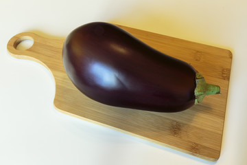 Fresh ripe eggplant over the cutting board.