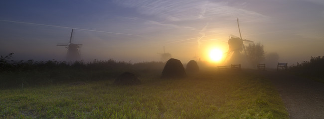 Fototapeta na wymiar Early morning mist on an autumn morning in the Kinderdijk UNESCO Heritage centre of windmills near Rottterdam, Netherlands